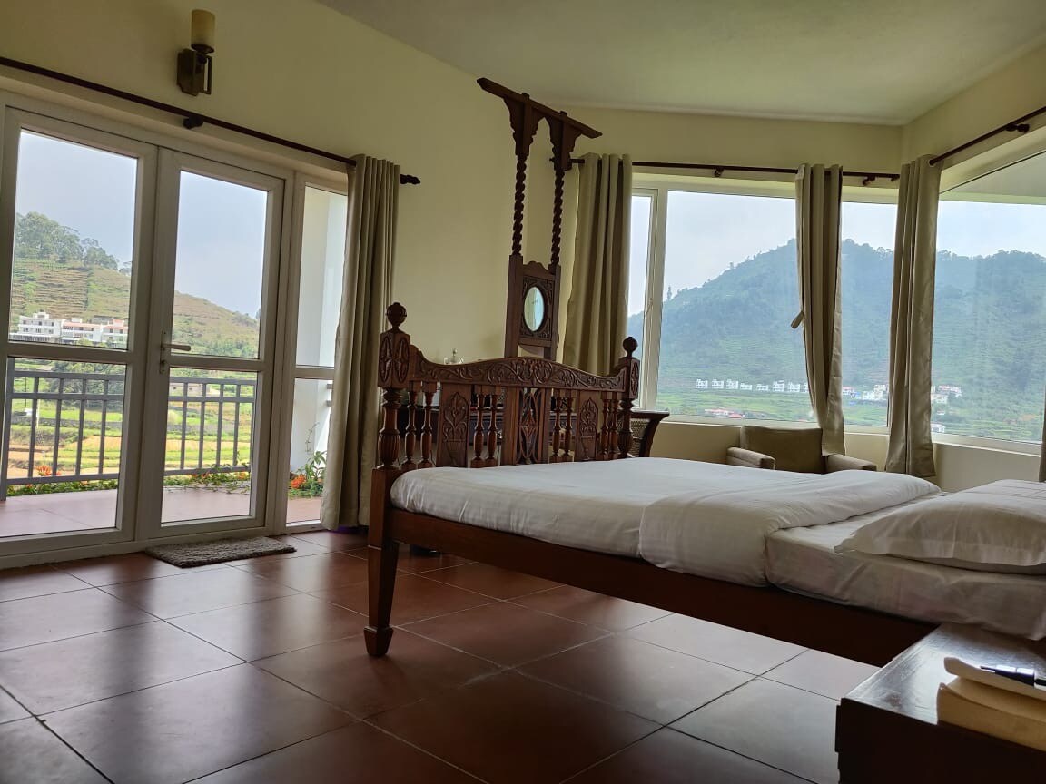 Bedroom with large windows and Kodaikanal valley view